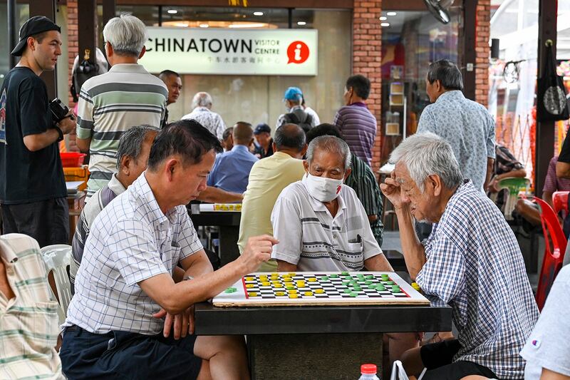 Men play checkers game in Singapore's Chinatown on Jan. 26, 2024. (Roslan Rahman/AFP)