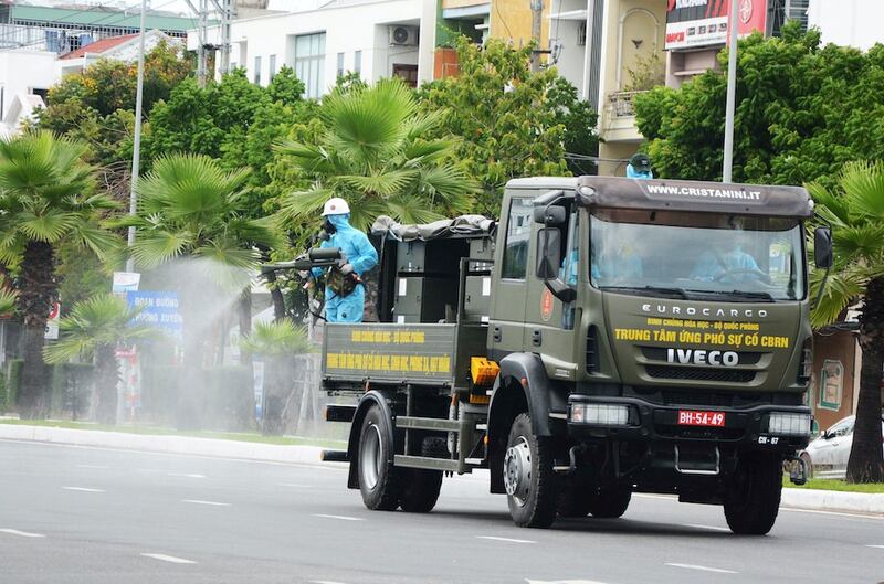 Hình minh hoạ. Một người lính phun thuốc khử trùng từ xe của quân đội trên đường phố Đà Nẵng hôm 3/8/2020