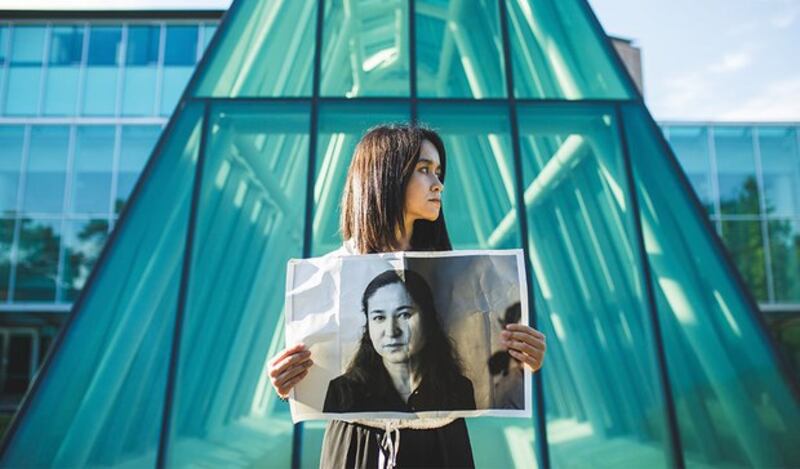 Akida Polat holds a photo of her mother, imprisoned Uyghur folklore expert Rahile Duwat. Credit: X/@Kuzzat_Altay