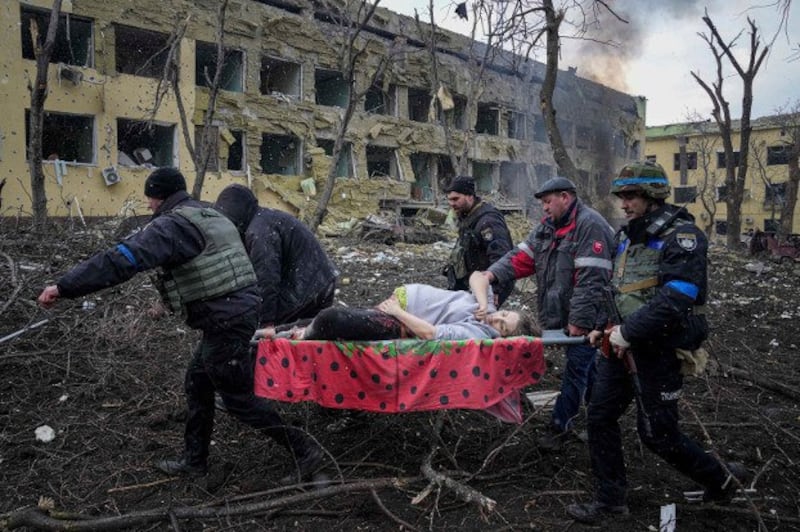 Ukrainian emergency employees and volunteers carry an injured pregnant woman from a maternity hospital damaged by shelling in Mariupol, March 9, 2022. The woman and her unborn baby did not survive. Credit: AP