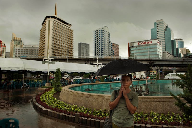 A Thai man prays in the rain during an all-religion prayer meeting for peace and harmony at the Lumpini park, in Bangkok in 2010. Thousands of residents gathered at dawn to pray for peace at sites across Bangkok where people were killed and high rise buildings torched in two months of political violence. Credit: Manish Swarup/AP