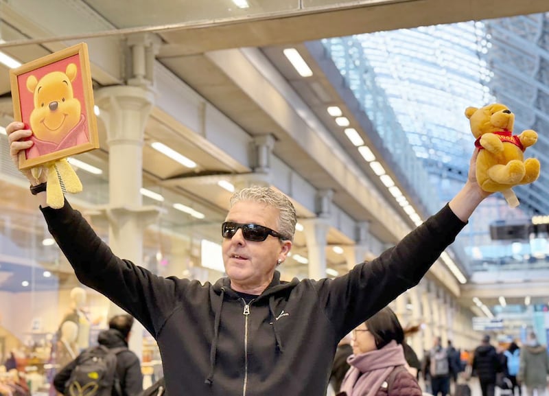 YouTuber Brendan Kavanagh holds up a Winnie the Pooh doll, which is banned in China, after playing the public piano at London's St. Pancras railway station on Jan. 26, 2024. (RFA)