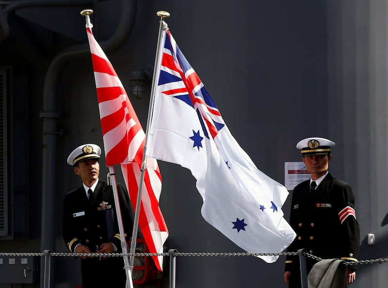 A file photo showing crew members from the Japanese Maritime Self-Defense force ship Umigiri standing on deck between Japan's Self-Defense Force flag alongside an Australian flag before joint military exercises at Garden Island Naval Base in Sydney, Australia, April 19, 2016. Credit: Reuters