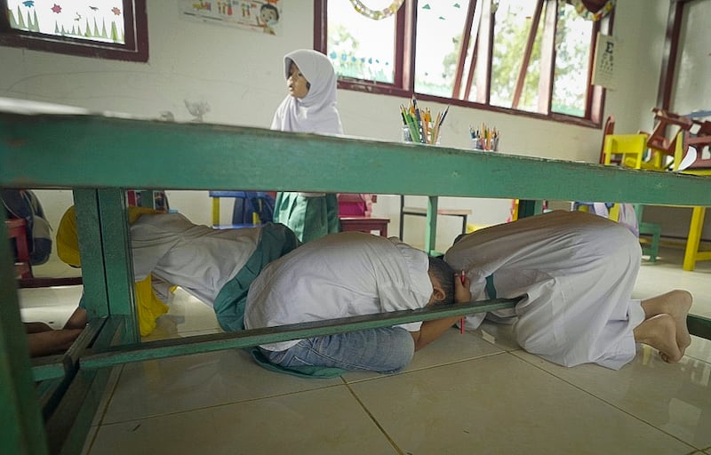 Kindergarten students in Lhoknga, Aceh province, Indonesia, conduct a tsunami drill in their classroom, Dec. 2, 2024.