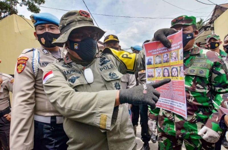 Inspector-General Abdul Rakhman Baso, the police chief in Indonesia's Central Sulawesi province, shows a poster of wanted members of the Eastern Indonesia Mujahideen militant group, in Palu, March 2, 2021. Credit: BenarNews