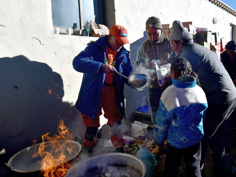 A firefighter distributes breakfast to  residents, Jan. 8, 2025, following the earthquake that struck Tingri county, in Shigatse, Tibet Autonomous Region, China,  Jan. 8, 2025.