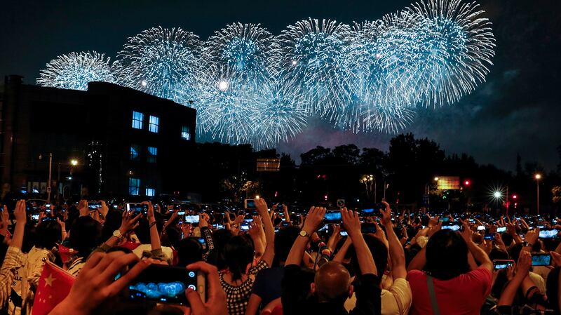 中国国庆70周年上的学生们在拍摄烟火。（美联社）