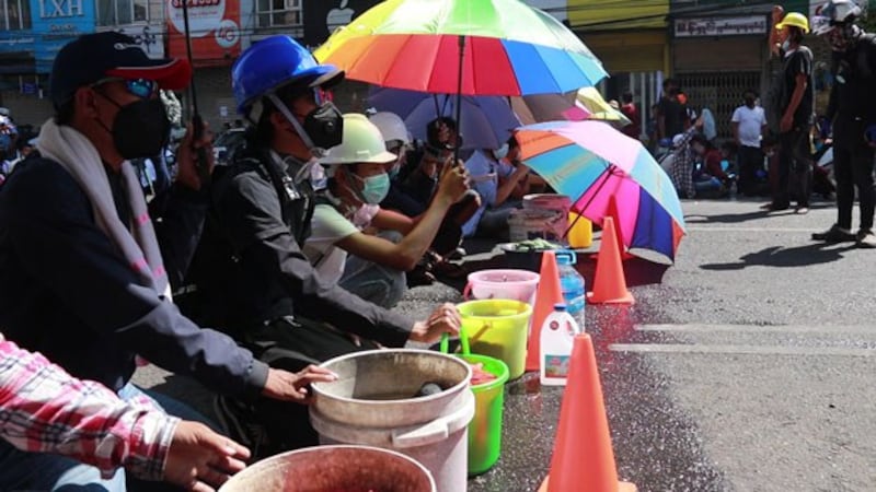 myanmar-protesters-water-buckets-tear-gas-yangon-mar1-2021.jpg