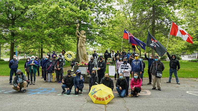 象徵香港民主的旗帜和雨伞出现在卑诗大学民主女神像六四纪念活动中。(主办方提供)