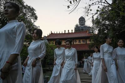 Hình minh hoạ. Những phụ nữ Việt Nam đi qua một tượng Phật tại chùa Khai Nguyên ở Sơn Tây, ngoại thành Hà Nội hôm 18/5/2019