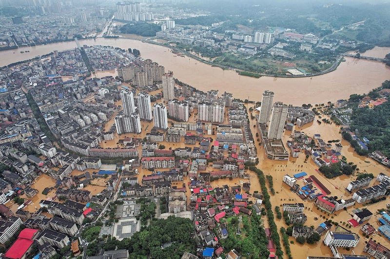 2024年7月2日，湖南省岳阳市大雨过后，建筑物和街道被洪水淹没。（法新社）