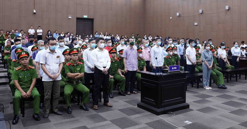 Defendants [front row, standing] appear in court for the repatriation flight trial in Hanoi, Vietnam, July 11, 2023. Credit: Vietnam News Agency/AFP