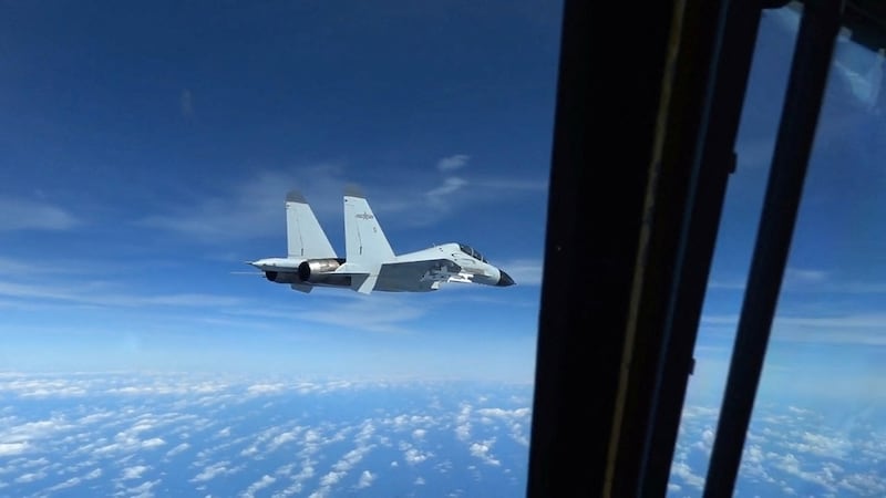 A Chinese Navy J-11 fighter jet flies near a U.S. Air Force RC-135 reconnaissance aircraft in international airspace over the South China Sea, according to the U.S. military, Dec. 21, 2022.