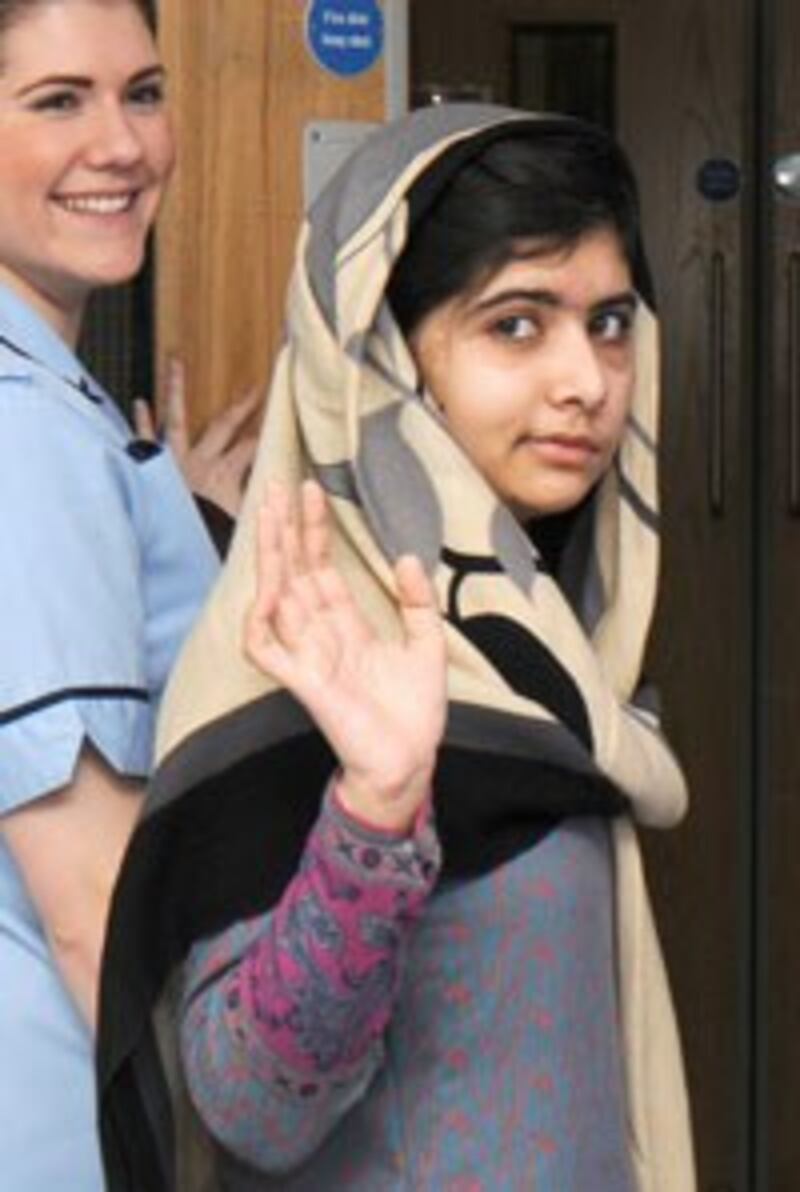 Cô Malala Yousafzai vẫy tay chào trước khi cô xuất viện hôm 04/1/2013 tại Bệnh viện Queen Elizabeth ở Birmingham, Anh Quốc. AFP photo