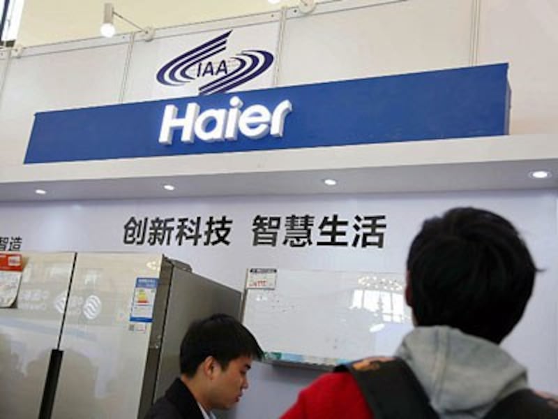 Chinese visitors look at electric home appliances manufactured by Haier Group at an expo in Shanghai, Nov. 27, 2015.