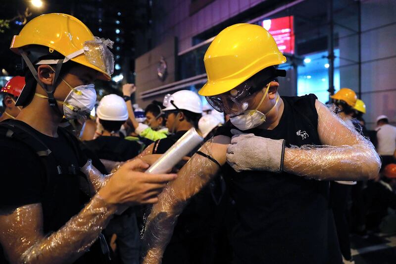 2019年6月21日，抗议者聚集在香港警察总部附近，用塑料包裹手臂以防胡椒喷雾。（美联社）