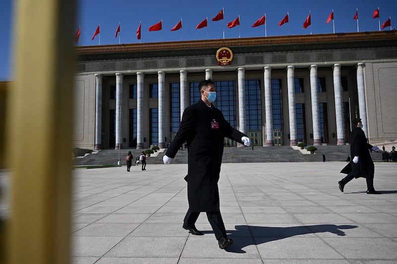 Security personnel walk outside the Great Hall of the People after the second plenary session of the 14th National People's Congress in Beijing on March 8, 2024. (Jade Gao/AFP)