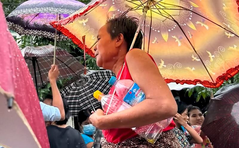 A woman waits in line in suburban Yangon, Myanmar, with bottles to fill with palm oil, Sept. 15, 2023. Credit: RFA