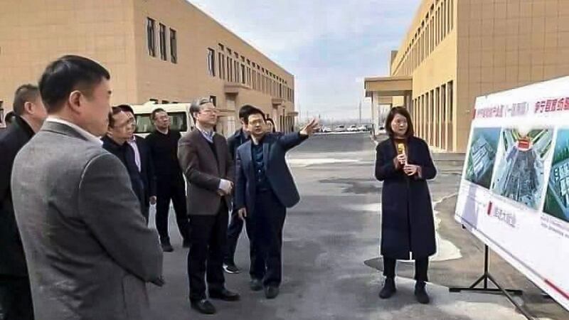 Visiting officials are briefed outside of the Zhuowan factory, in an undated photo.