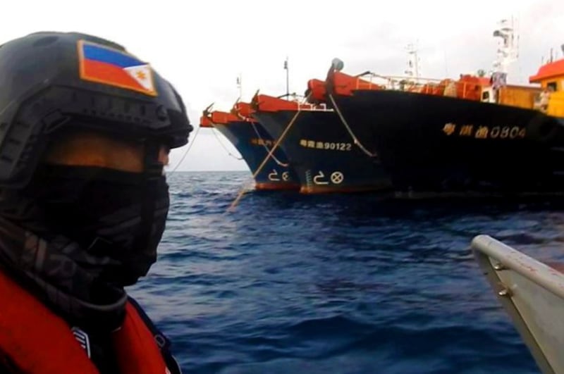 Philippine Coast Guard members in rubber boats patrol near Chinese ships moored at Whitsun Reef in the South China Sea, April 14, 2021. Credit: Philippine Coast Guard via AP