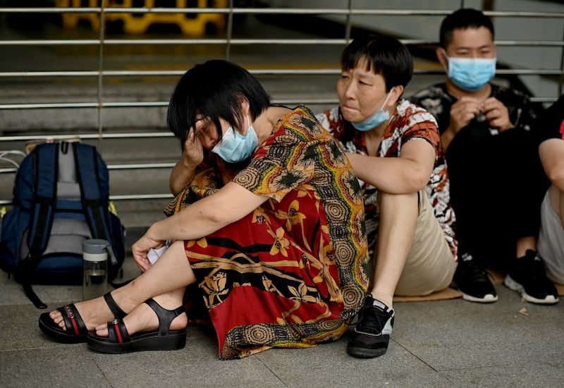 A woman cries as she and other people gather at the Evergrande headquarters in Shenzhen, southeastern China, as the Chinese property giant said it is facing "unprecedented difficulties," Sept. 16, 2021. Credit: AFP