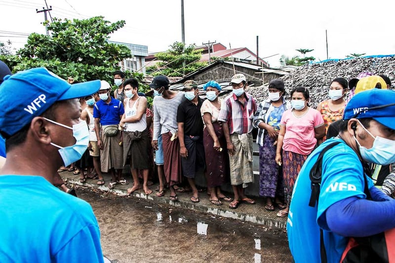 People wait to receive bags of rice from the World Food Program. More than 26 percent of Myanmar's population lives below the poverty line. (AFP)