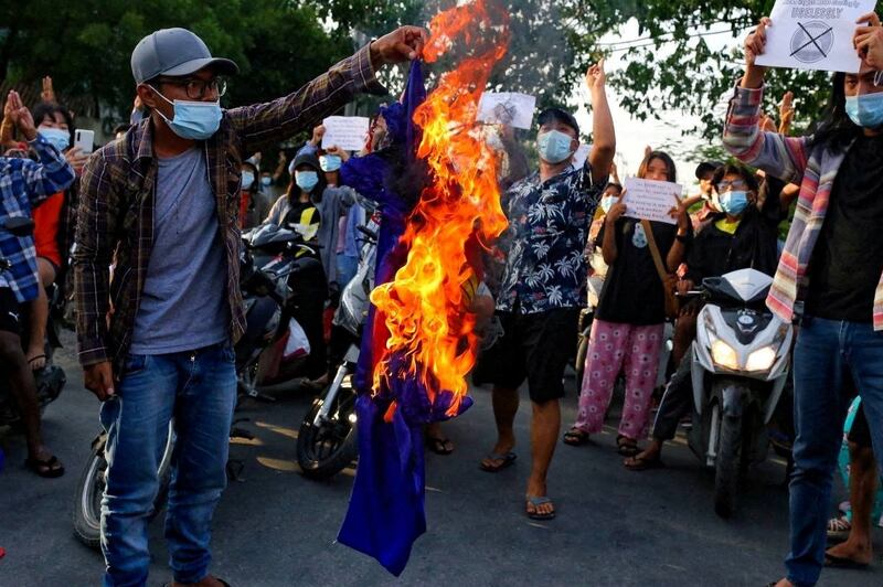 Protesters against Myanmar's junta burn the flag of the Association of Southeast Asian Nations (ASEAN), in Mandalay, June 5, 2021. Reuters