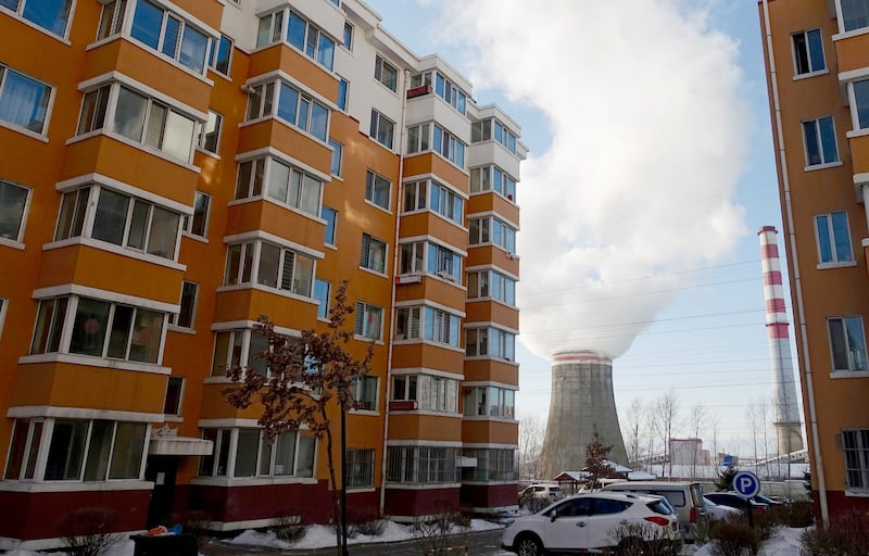 Smoke billows from a cooling tower of a thermal power plant near residential buildings in the coal city of Hegang, Heilongjiang province, northeastern China, Jan. 2, 2020. Credit: Reuters