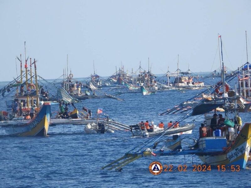 A China Coast Guard boat shadows a Philippine Bureau of Fisheries and Aquatic Resources inflatable boat while it delivers supplies to fishermen during a mission near the China-controlled Scarborough Shoal in the disputed South China Sea, Feb. 22, 2024. (AFP/Philippine Coast Guard handout)