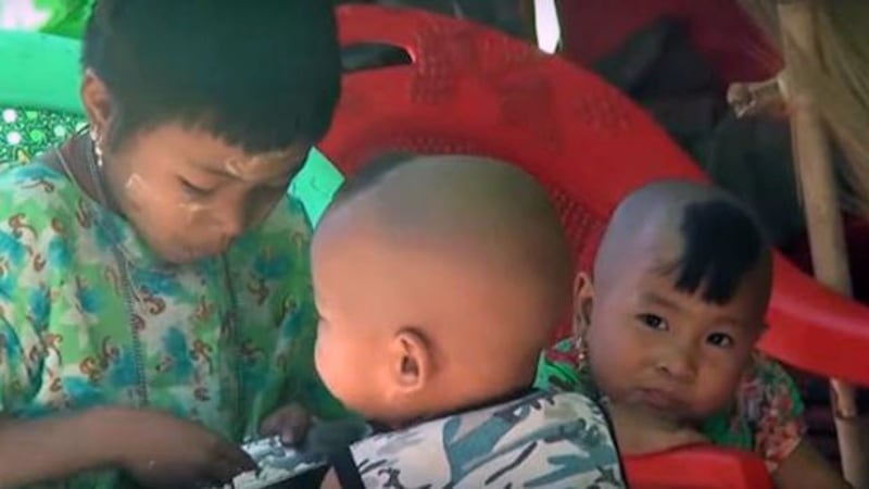 Children displaced by armed conflict eat rice from a bowl at the Nyaungchaung IDP camp in Kyauktaw township, western Myanmar's Rakhine state, April 13, 2020.