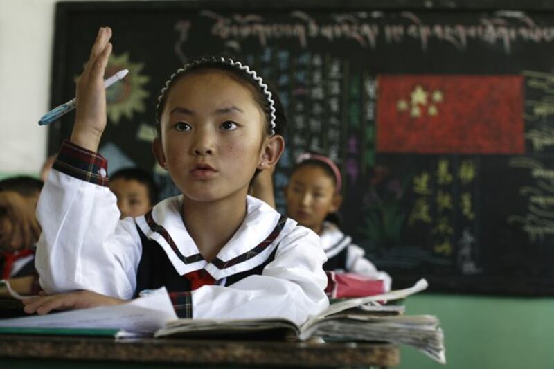 A girl raises her hand to answer a question during a Tibetan language class at the Lhasa Experimental Primary School in Lhasa, capital of western China's Tibet Autonomous Region, June 19, 2009. (Greg Baker/AP)