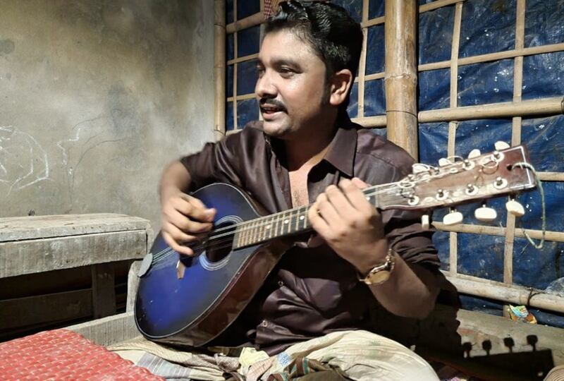 Sirajul Islam, a Rohingya musician, performs at a refugee hut in Cox's Bazar, Bangladesh, July 23, 2022. Credit: Sharif Khiam/BenarNews