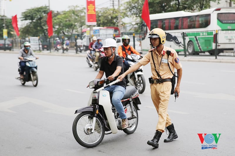 Ảnh minh họa. CSGT dừng một người lưu thông bằng xe máy để kiểm tra.