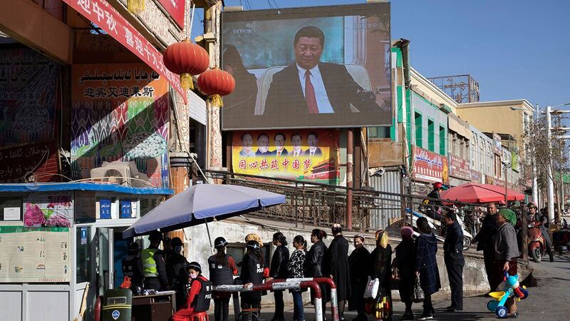 资料图片：2017 年 11 月 3 日，居民通过安全检查站进入和田集市。 （㺯联社）