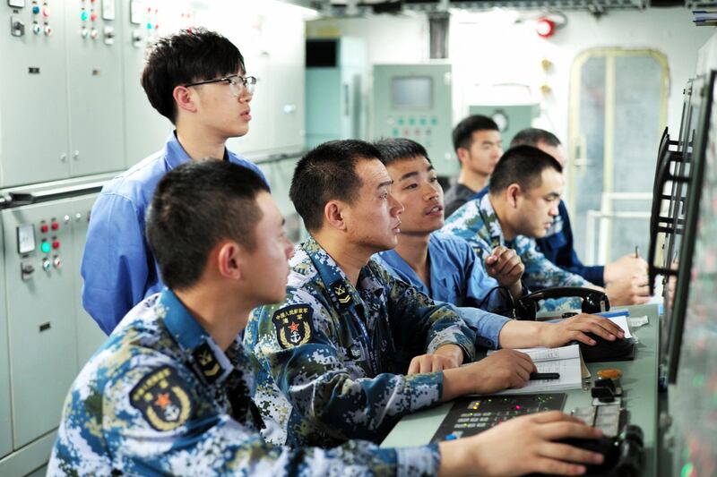 People's Liberation Army Navy sailors working on board China's first domestically manufactured aircraft carrier, during its first trial at sea, which began on May 13, 2018. Credit: AFP