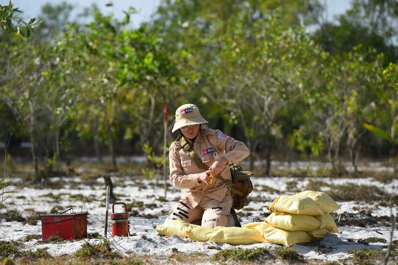 This picture taken on January 6, 2020 shows a member of an all-female demining team preparing to detonate unexploded ordnance at a landmine site in the Trieu Phong district in Quang Tri province. More than 6.1 million hectares of land in Vietnam remain blanketed by unexploded munitions -- mainly dropped by US bombers -- decades after the war ended in 1975. (Photo by Nhac NGUYEN / AFP) / TO GO WITH Vietnam-US-weaponry-landmines,FOCUS by Tran Thi Minh Ha