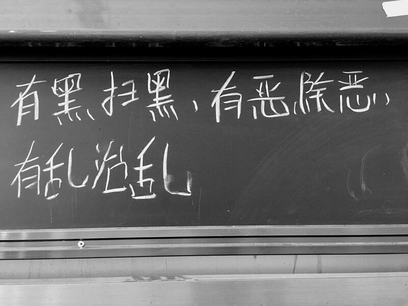 The slogan "Where darkness arises, sweep it away; where evil arises, eliminate it; where chaos arises, govern it." is seen at Paxiang Central Primary School during a 2019 trip to Xinjiang by a Taiwanese delegation that included high-school students.