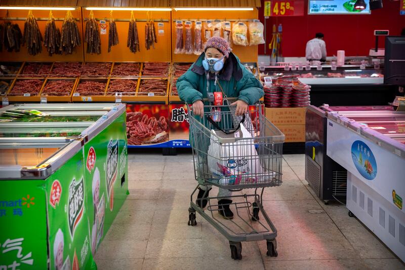 A woman with a face mask pushes her trolley at a grocery store in Beijing, in 2020. China's post-pandemic economic consumption recovery didn't happen as expected.Credit: Mark Schiefelbein/AP