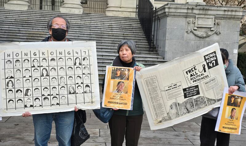 民众拿着四十七名个民主派骨干分子的头像和事件说明图板，向街头路人说明四十七人案的意义。 (记者柳飞拍摄)