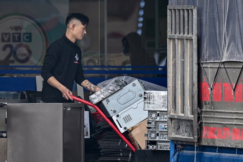 A man transports equipment being removed from the VTC Digital Television office building in Hanoi on January 15, 2025.