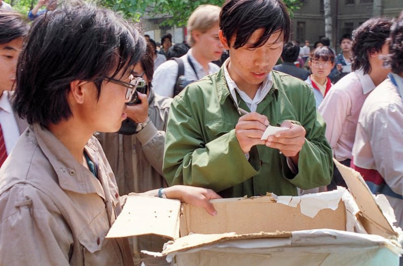 1989年5月3日，一名大学生在选票上写下名字，推举与中国当局对话的代表。（亨丽埃特/法新社）