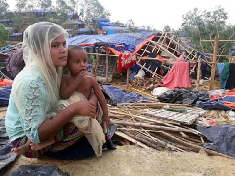 Rohingya refugees sit near a house destroyed by Cyclone Mora in a camp in Cox's Bazar, Bangladesh, May 31, 2017. 