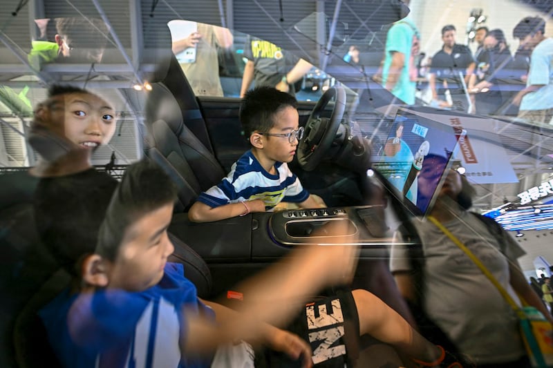 Children are seen inside a Xiaomi SU7 electric vehicle on display during the World Intelligence Expo in Tianjin, June 23, 2024. (Pedro Padro/AFP)