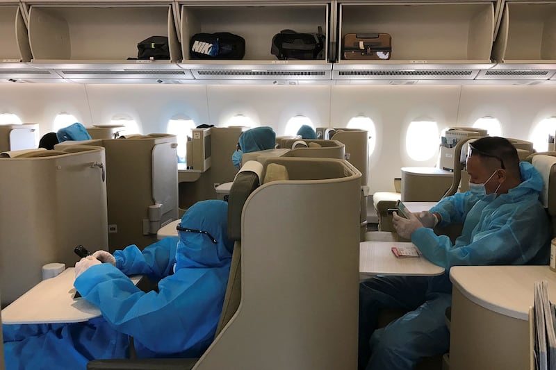 Vietnamese nationals wearing protective suits are seen aboard a repatriation flight from Singapore to Vietnam, Aug. 7, 2020. Credit: Mai Nguyen/Reuters