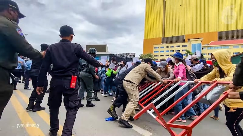 Police and striking NagaWorld protesters struggle over a barricade in Phnom Penh in a screengrab from a video, Aug. 11, 2022. Credit: Citizen journalist