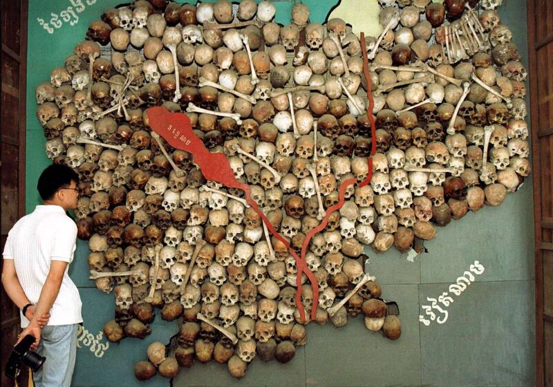 A visitor stands before a map of Cambodia made from the skulls and bones of victims of the Khmer Rouge's brutal 1975-79 "killing fields" regime at Tuol Sleng in Cambodia, June 23, 1997. Credit: Reuters