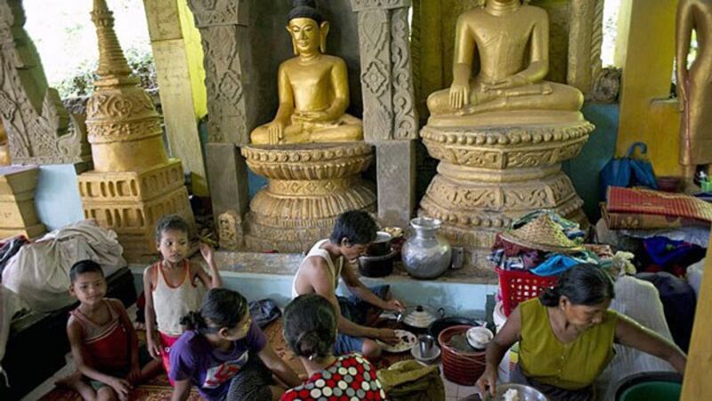 Flood-affected Myanmar villagers eat a meal while taking shelter inside a pagoda in Mrauk-U township, western Myanmar's Rakhine state, Aug. 5, 2015.