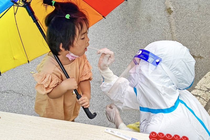 A health worker takes a swab sample from a child to be tested for the Covid-19 coronavirus in Sixian county, Suzhou city, in China's eastern Anhui province, July 4, 2022. Credit: AFP