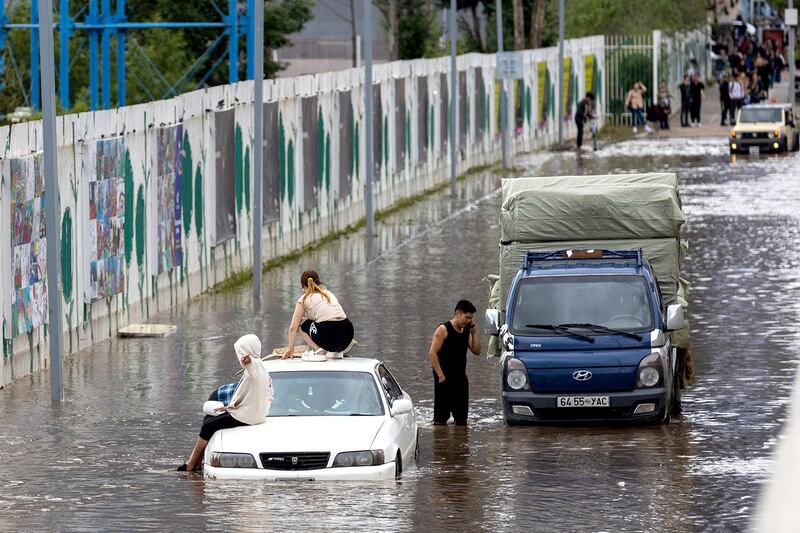 瞬间大雨后，乌兰巴托成了水乡泽国，多辆汽车泡在水里。（法新社）