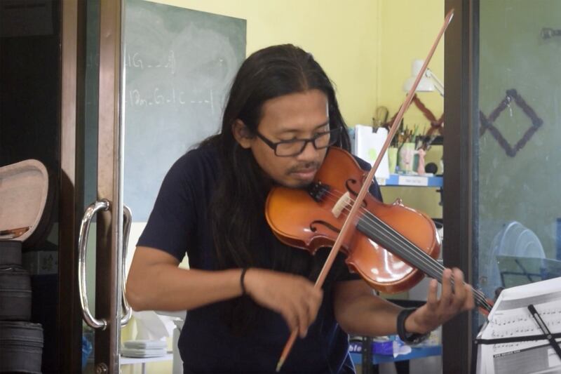 Phoe San plays the violin in a community center in Mae Sot, Thailand.